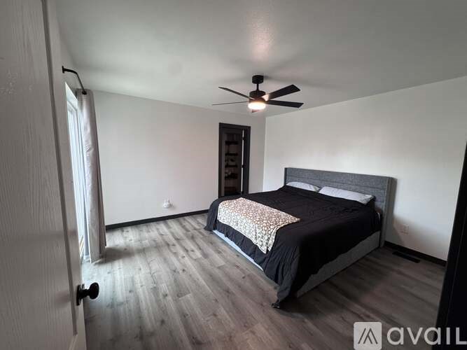 A bedroom with a bed, dresser, and a ceiling fan.