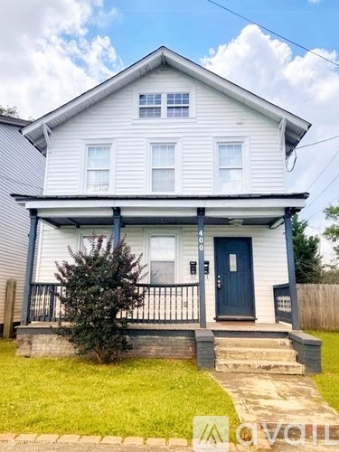 A two-story house with a blue door and white siding.