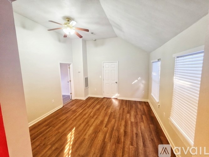 A room with wooden floors and a ceiling fan.