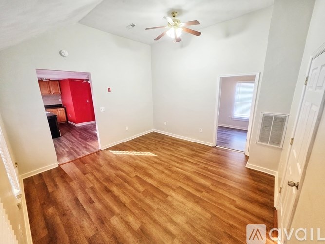 A room with wooden flooring and a ceiling fan.