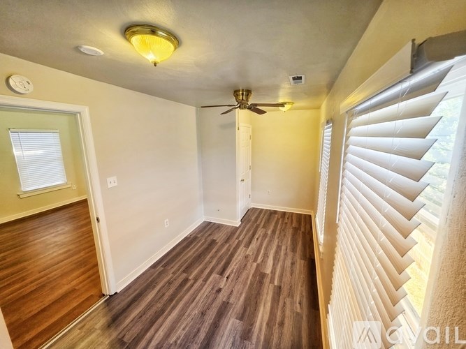 A room with a ceiling fan and sliding glass doors.