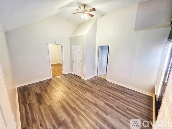 A room with wooden flooring and a ceiling fan.
