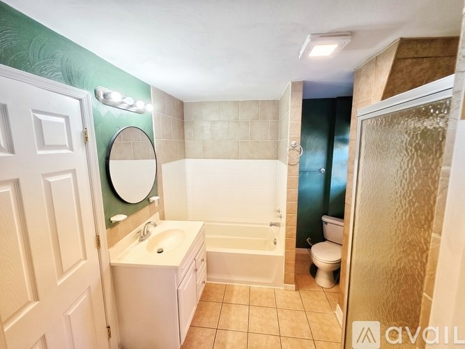 A bathroom with a white sink, toilet, and bathtub.