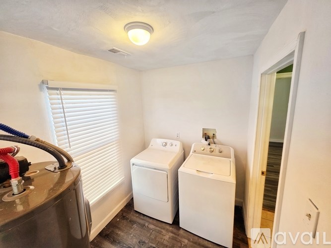 A bathroom with a toilet, sink, and window.