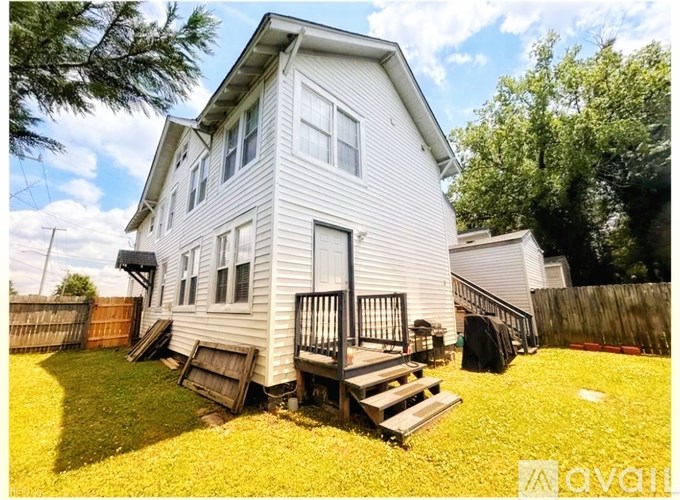 A two-story house with a deck and a fence.