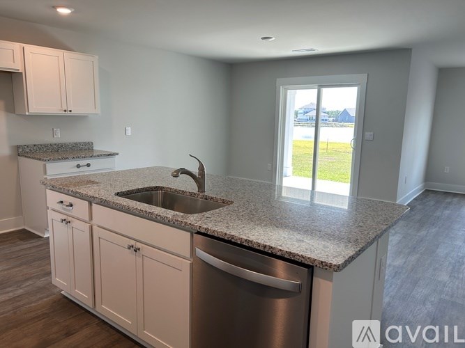 A kitchen with a granite countertop and stainless steel appliances.