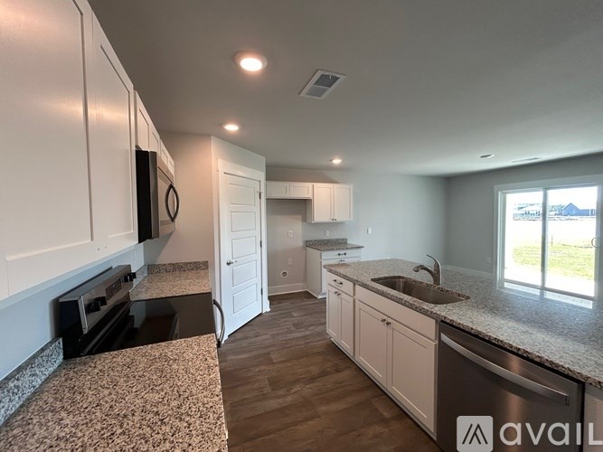 A kitchen with white cabinets and a granite countertop.