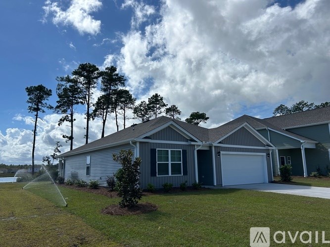 A house with a lawn and trees in front of it.