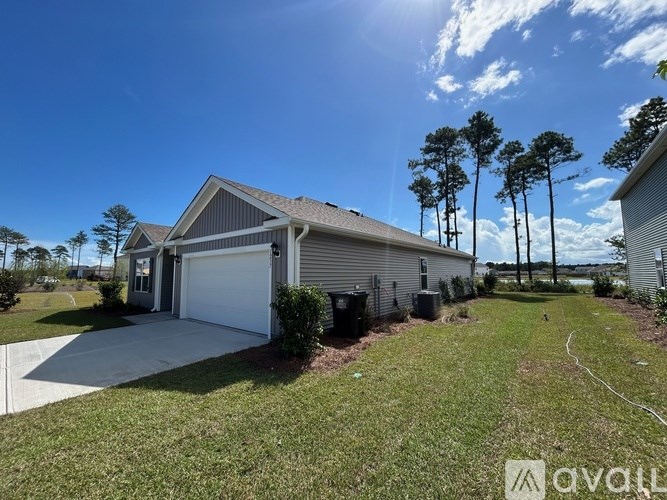 A house with a garage and a driveway in front of it.