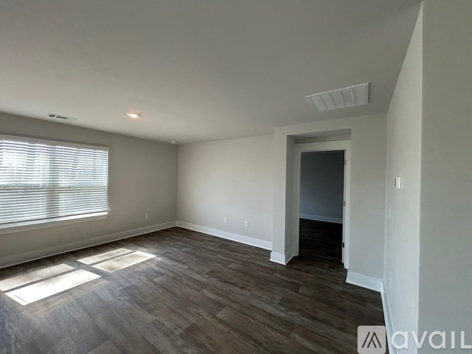 A room with a window and wooden flooring is available for rent.