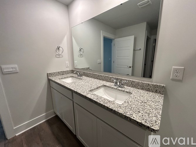 A bathroom with a granite countertop and a large mirror.