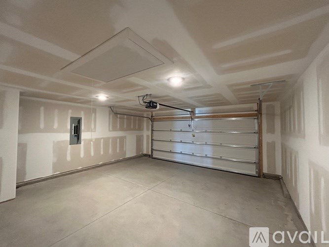 A spacious garage with a closed door and a ceiling fan.