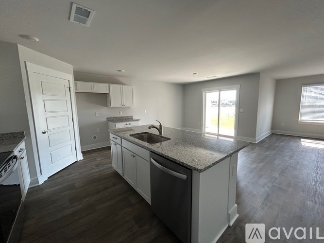 A kitchen with a sink, stove, and cabinets.