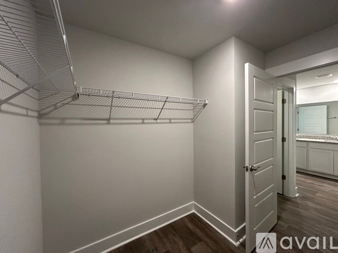 A walk-in closet with a white door and shelving.