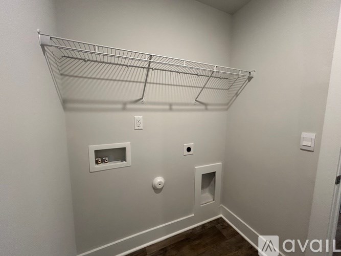 A white wall with a shelf and a vent.