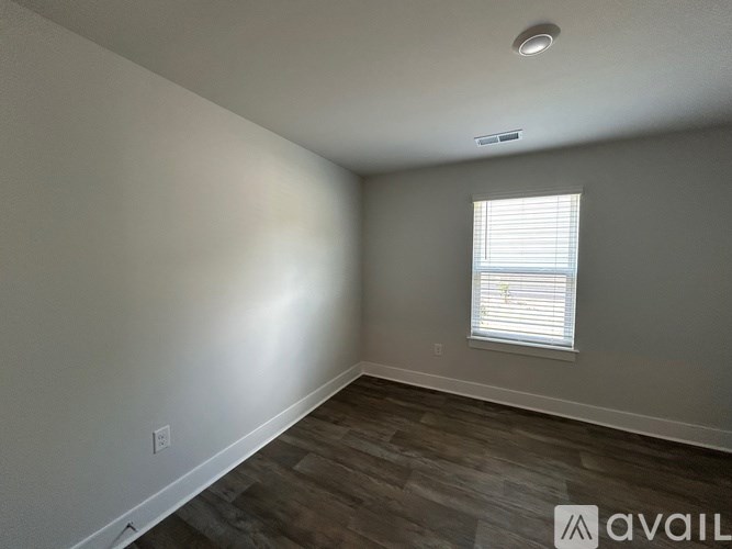 A room with a window and wooden flooring.
