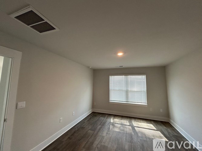A room with a window and wooden flooring.