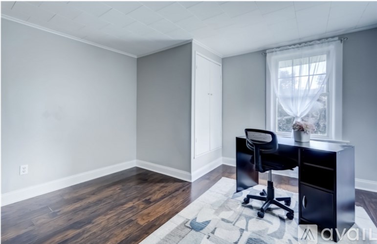 A room with a desk and chair in it.