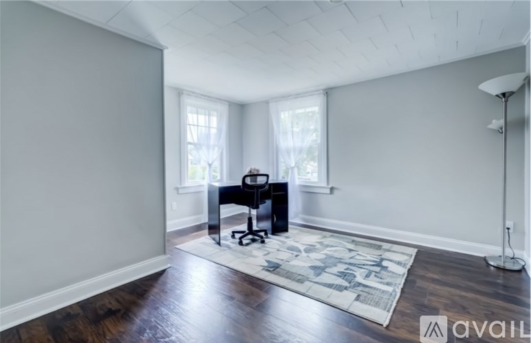 A room with a desk and a chair in it.