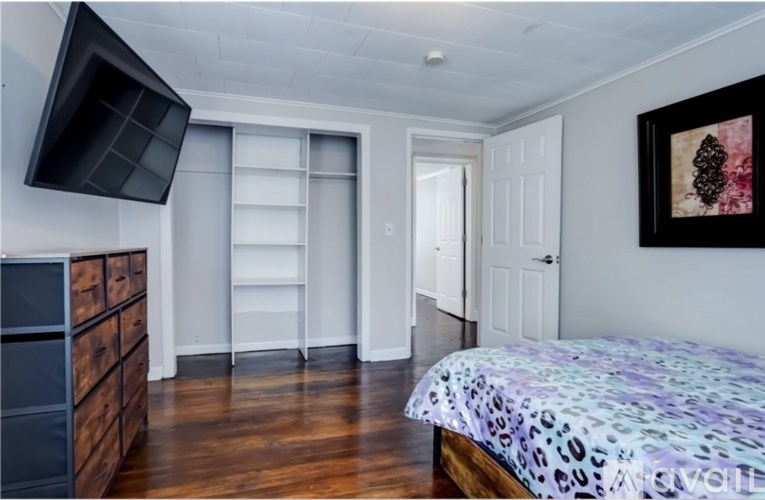 A bedroom with a leopard print bedspread and a wooden dresser.