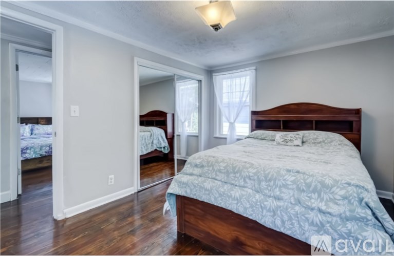 A bedroom with a large bed and a mirror on the wall.