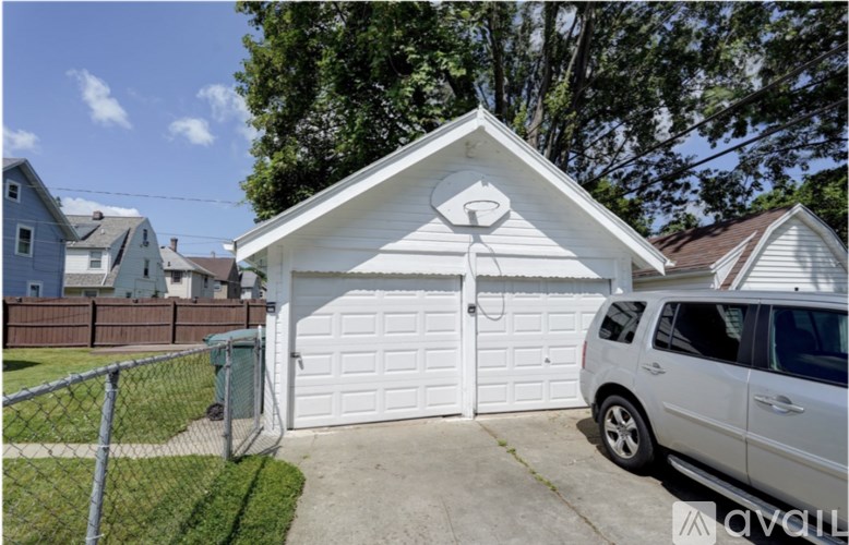 A white garage with a car parked in front.