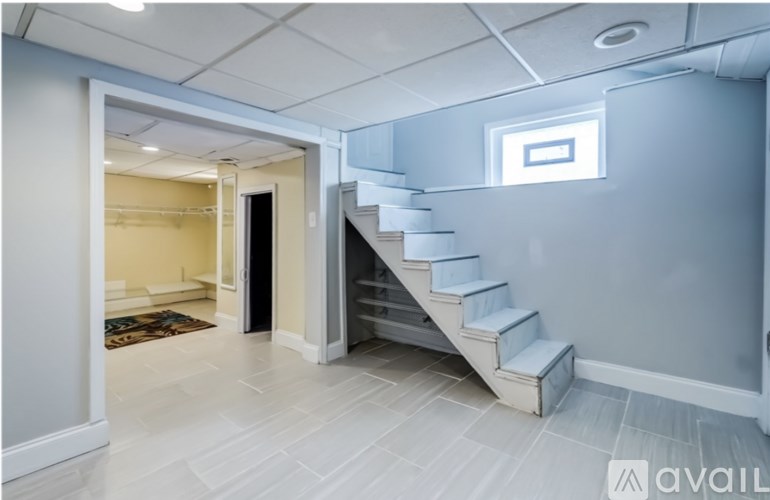 A staircase with a skylight above it in a room with white walls.