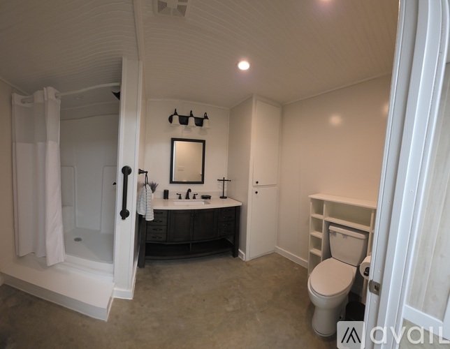 A bathroom with a toilet, sink, and shower.