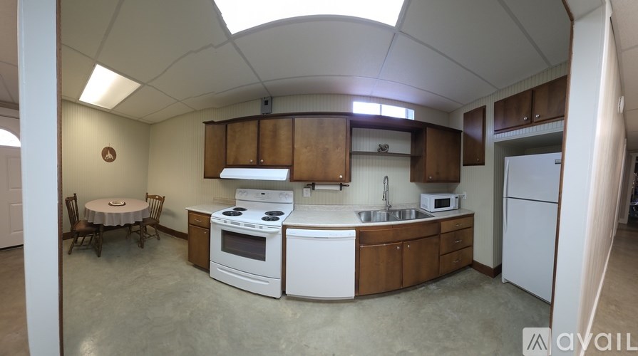 A kitchen with white appliances and wooden cabinets.