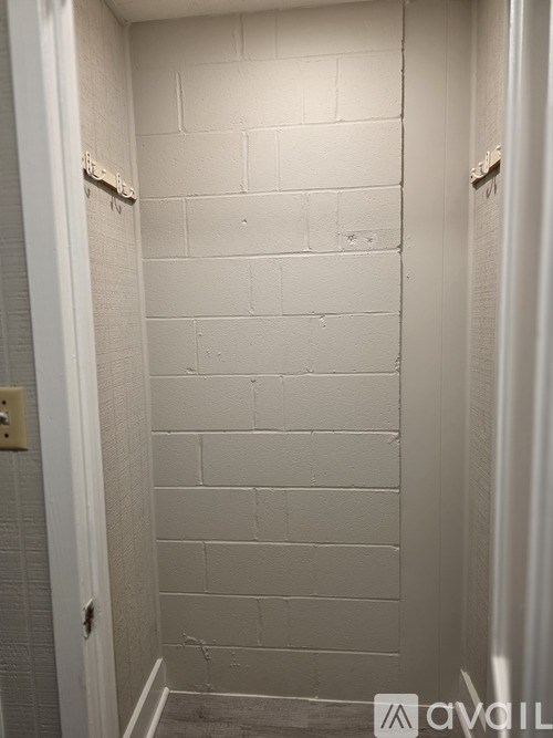 A white bathroom with a white tiled shower wall.