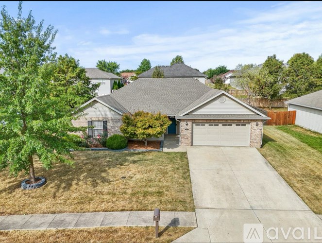 A house with a driveway and a tree in front.