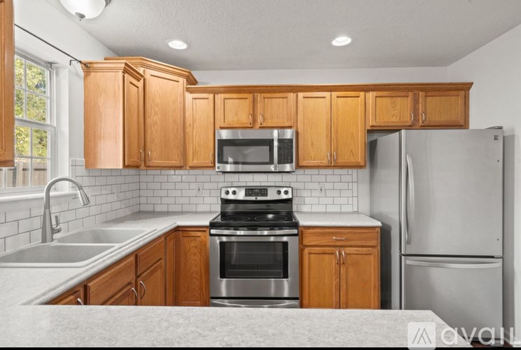 A kitchen with wooden cabinets and stainless steel appliances.