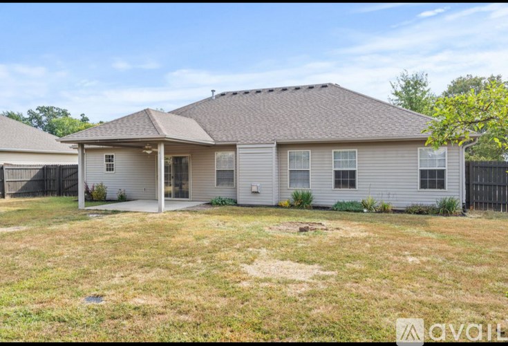 A house with a brown roof and a white fence is for sale.