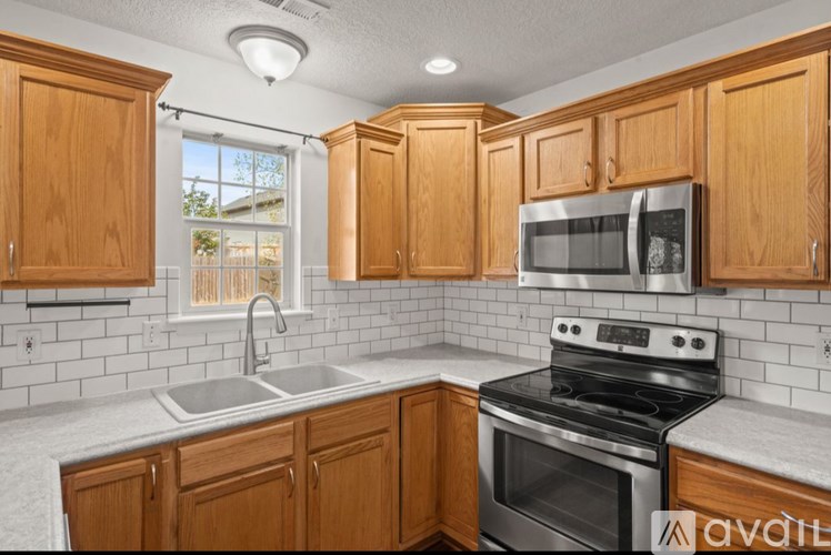 A kitchen with wooden cabinets and a stainless steel oven.