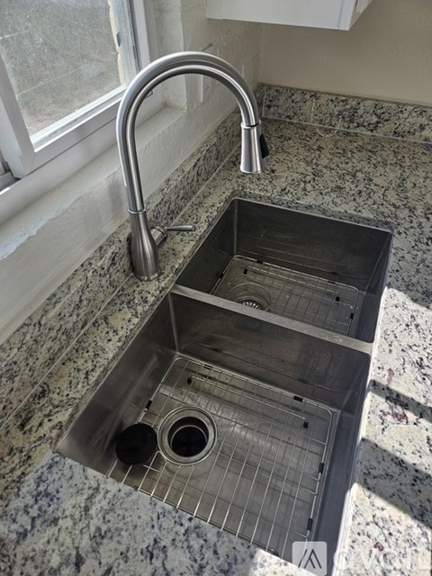A kitchen sink with a chrome faucet.