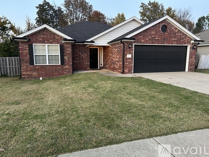 A brick house with a black garage door and a white window.