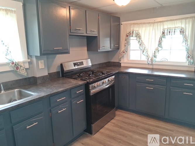A kitchen with a stove top oven and a sink.
