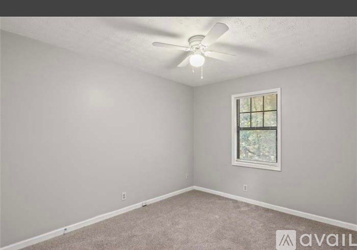 A room with a ceiling fan and a window.