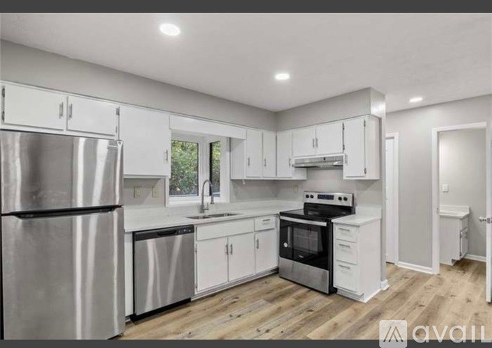 A modern kitchen with stainless steel appliances and white cabinets.
