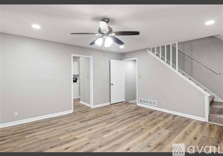 A room with a ceiling fan and wooden flooring.