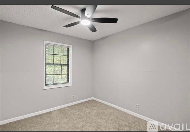A room with a ceiling fan and a window.