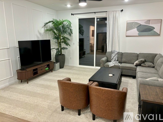 A living room with a grey couch, a black coffee table, and a television on a wooden stand.