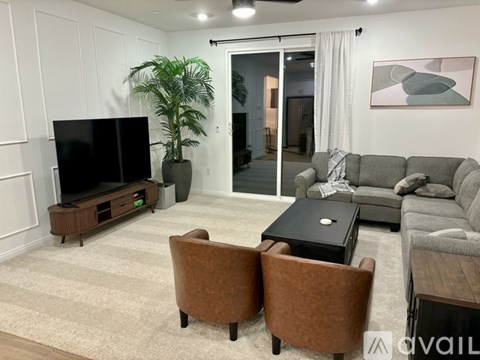A living room with a grey couch, a black coffee table, and a television on a wooden stand.