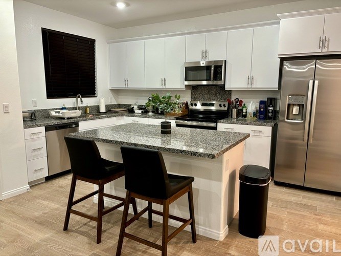 A kitchen with granite countertops and stainless steel appliances.