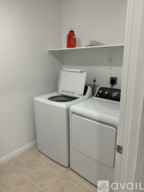 A white washing machine and dryer in a small laundry room.