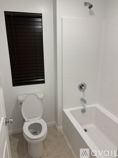 A white toilet and bathtub in a bathroom.
