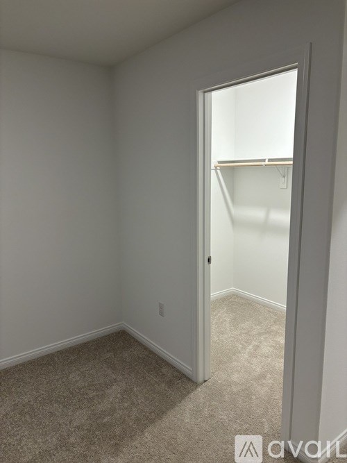 A room with a carpeted floor and a white door.