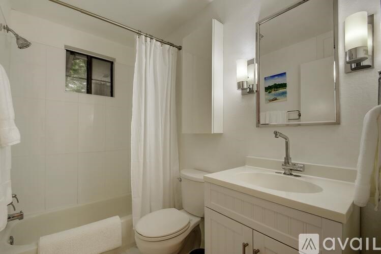 A bathroom with a toilet, sink, and shower.