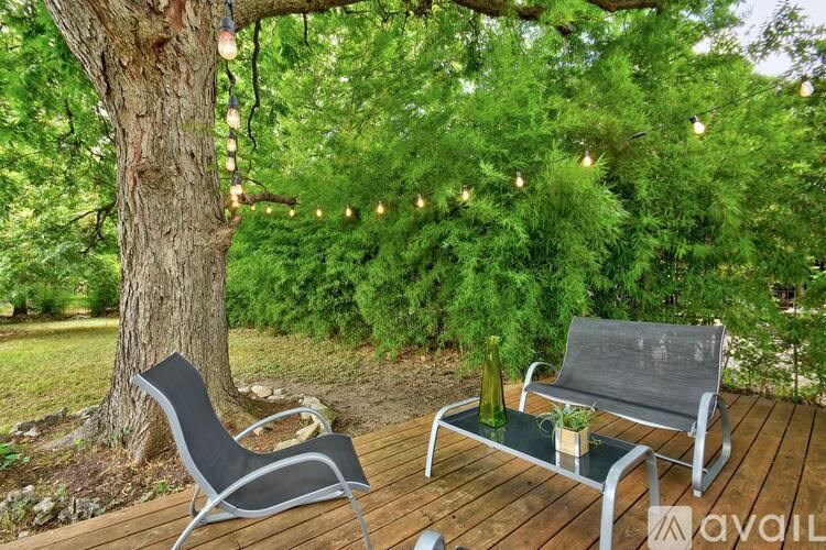 A black chair and a black bench are on a wooden deck.