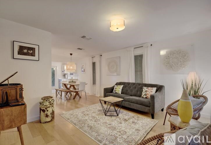 A living room with a grey couch and a wooden radio.
